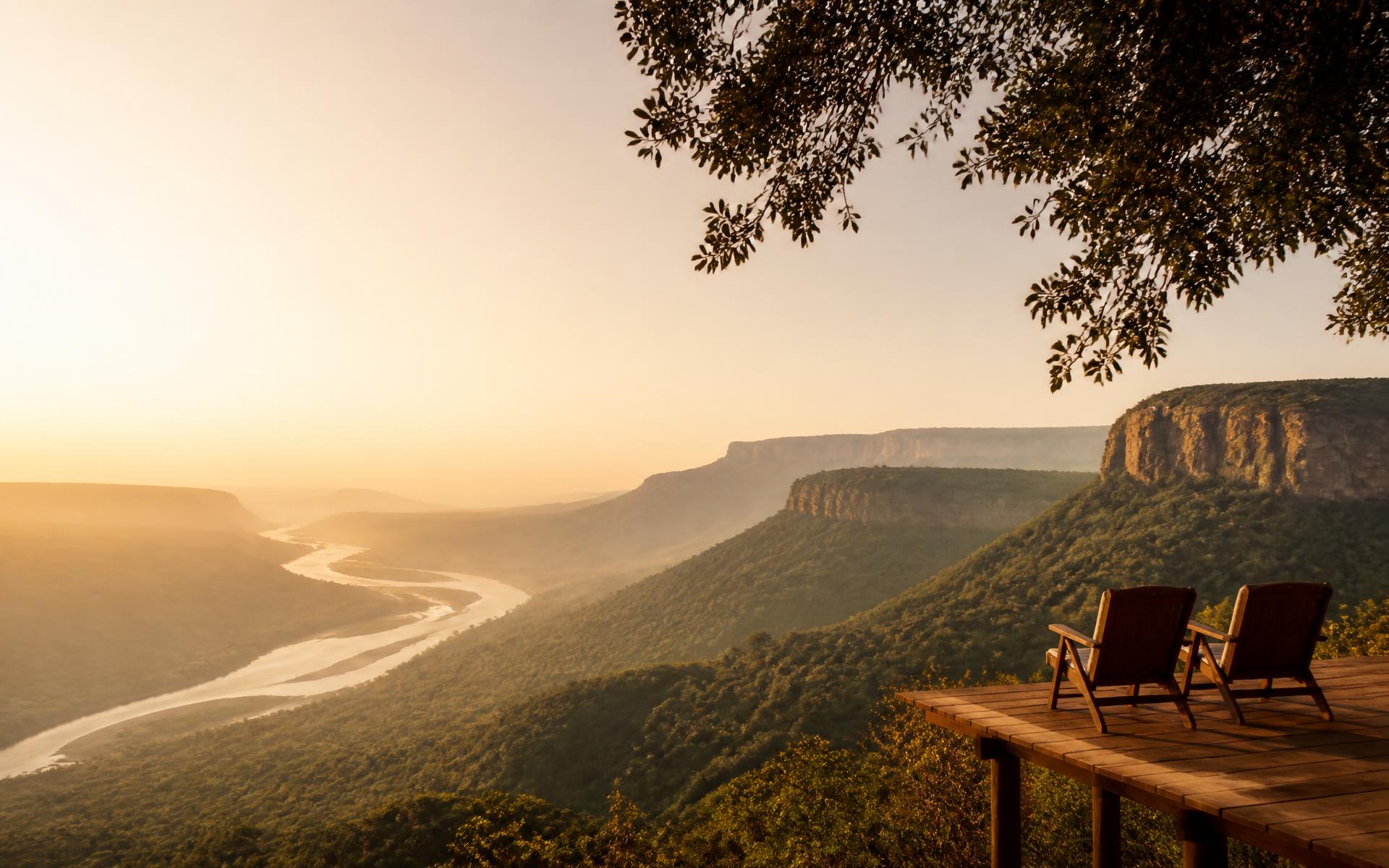 Misty river valley and escarpment at sunrise, seen from a lodge deck in southern Africa